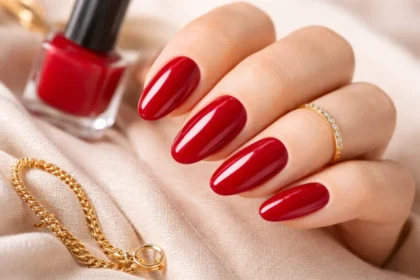 red nail polish cherry manicure on neatly shaped nails with glossy finish, soft neutral background, and minimal luxury accessories, no text